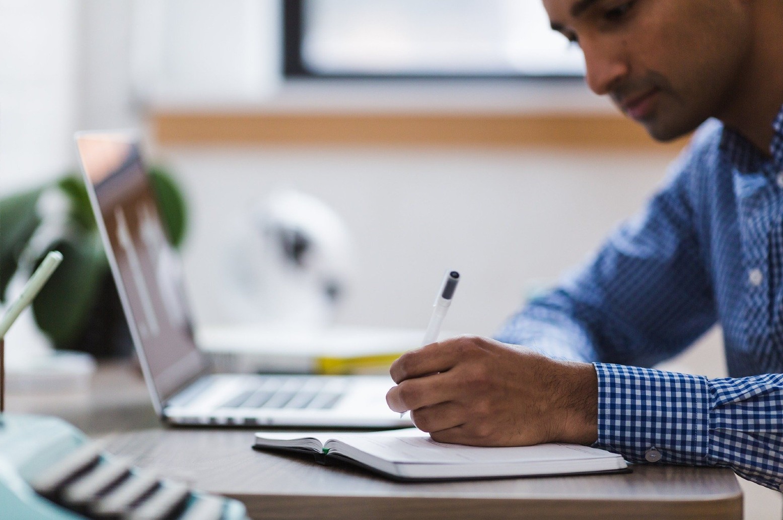 Man writing notes on paper with a pen.