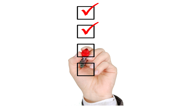 Close up of person's hand marking off a checklist item