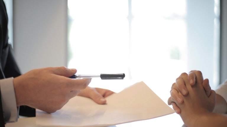 Preparing to sign documents with paper and pen.