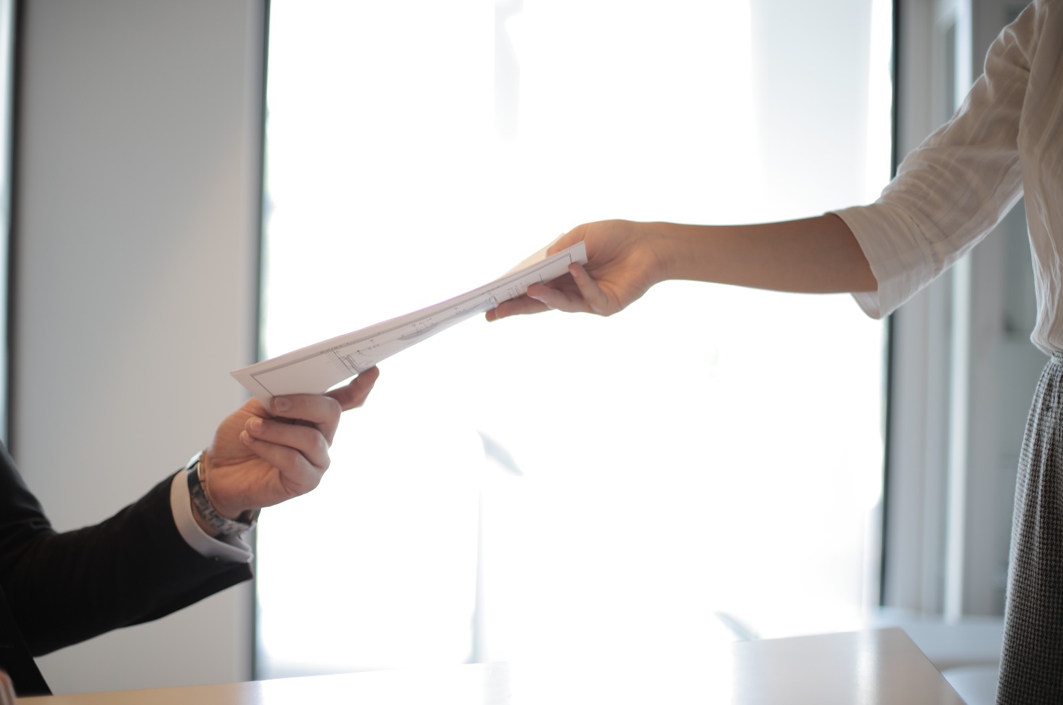 Handing paperwork to another person.